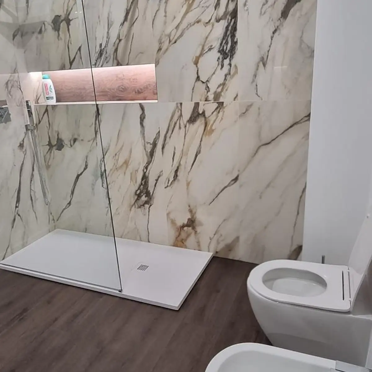 Area bar del ristorante Riff: elegante bancone con espositore ad arco, luci d'atmosfera e il caratteristico soffitto ondulato rosa.